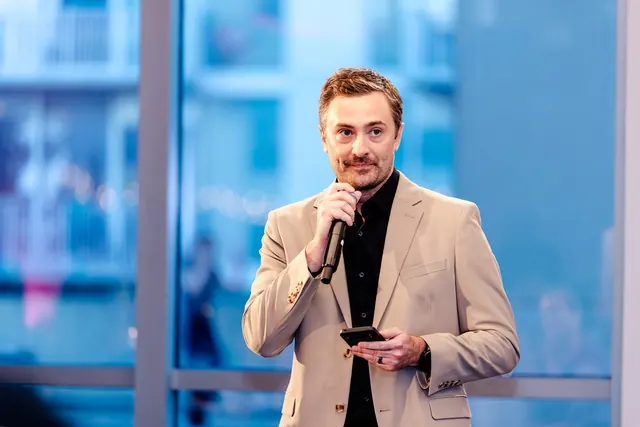 Speaker holding a microphone during the rooftop reception at the 2026 Goodness Gala