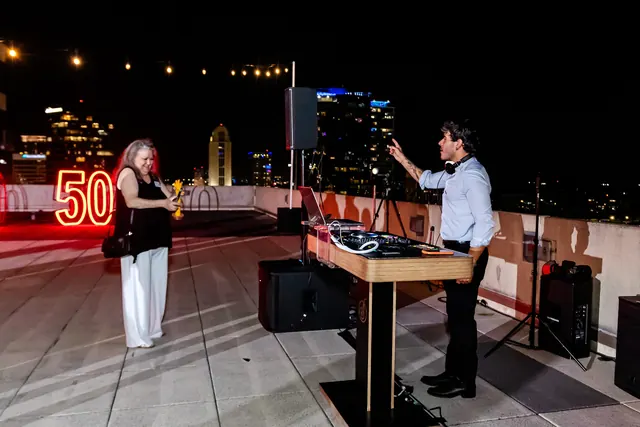 DJ performing beneath rooftop string lights at the 2026 Goodness Gala