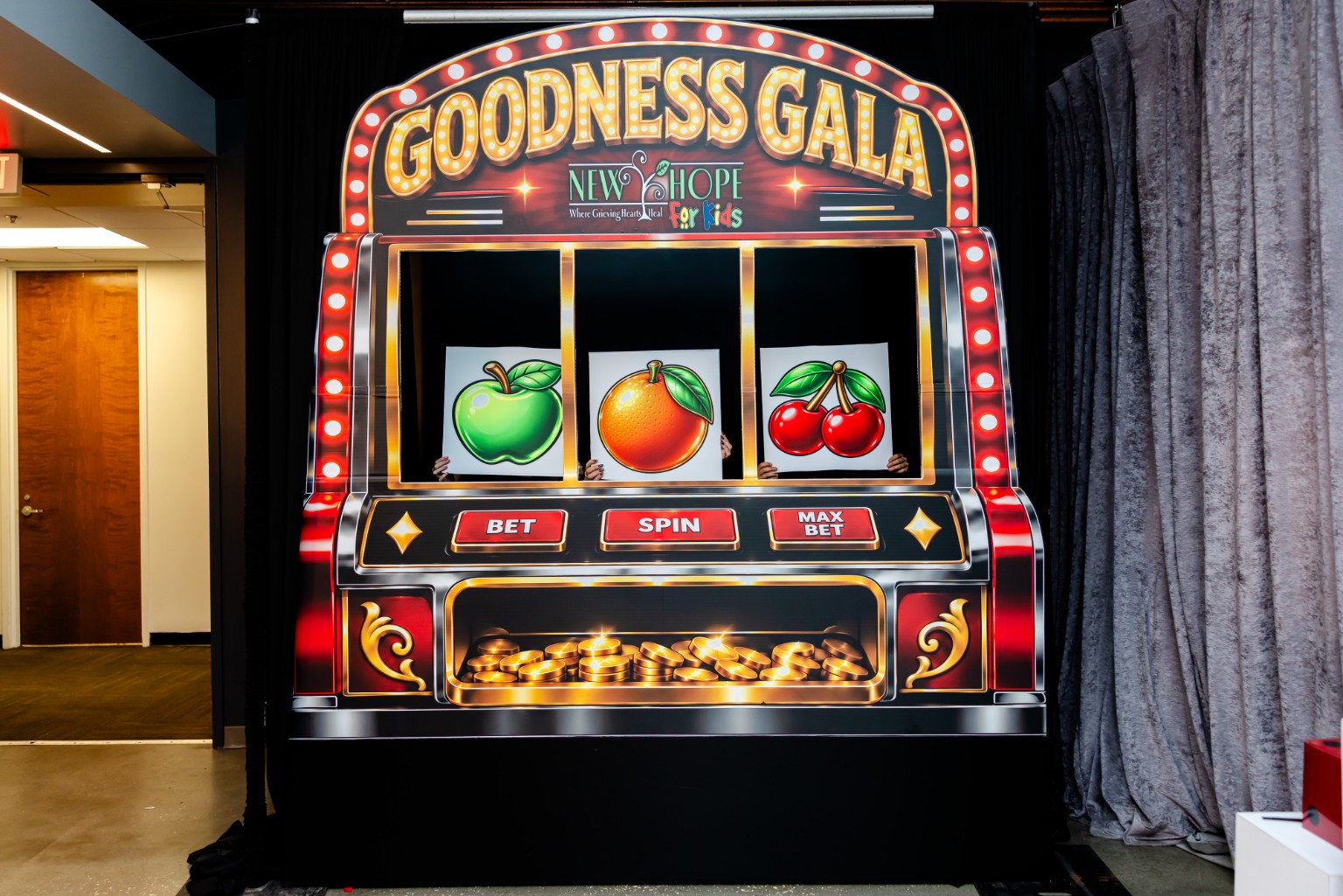Slot-machine photo backdrop with Goodness Gala and New Hope for Kids headings at the 2026 gala