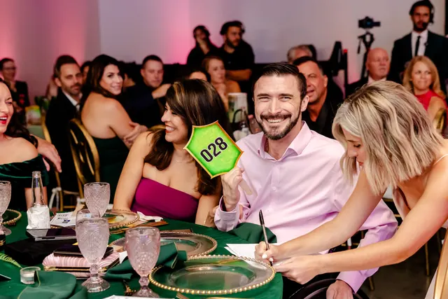 Guest raising a paddle during the gala at the 2025 Goodness Gala