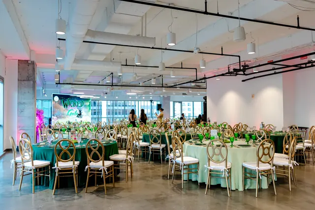 Dining room arranged with green tables and gold chairs at the 2025 Goodness Gala