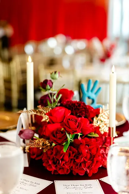 Red floral centerpiece with gold accents at the 2026 Goodness Gala
