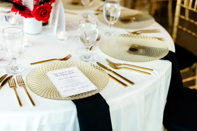 White table linens and gold place settings at the 2026 Goodness Gala